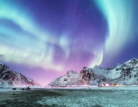 Aurora borealis on the Lofoten islands, Norway. Green northern lights above mountains. Night winter landscape with aurora. Natural background in the Norway