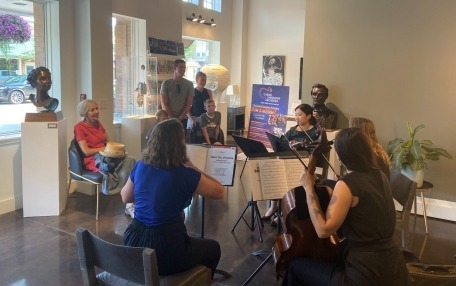 string quartet dressed casually playing in an art gallery at a community event.